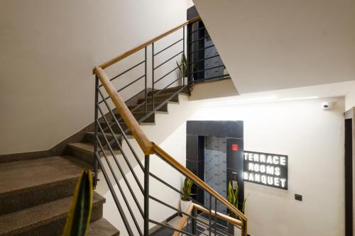 a staircase in a building with a sign on the wall at Leaf 9 Grand, Near Udyog vihar and Yashobhoomi in Gurgaon