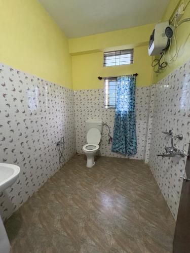a bathroom with a toilet and a sink and a window at The rolling hills Kaziranga in Hatikhuli
