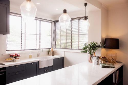 une cuisine avec un comptoir blanc et quelques fenêtres dans l'établissement HOBART 3 Bedroom, à West Hobart