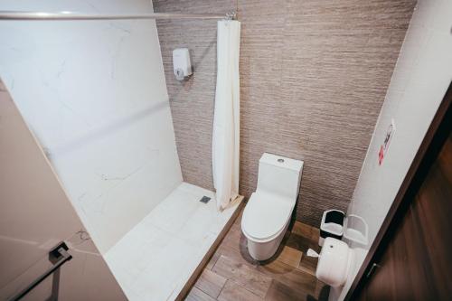 a small bathroom with a toilet and a shower at Hotel Villas Santander in Guatemala
