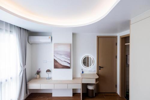 a white room with a table and a mirror at FantaSea condo Kamala 204 in Kamala Beach