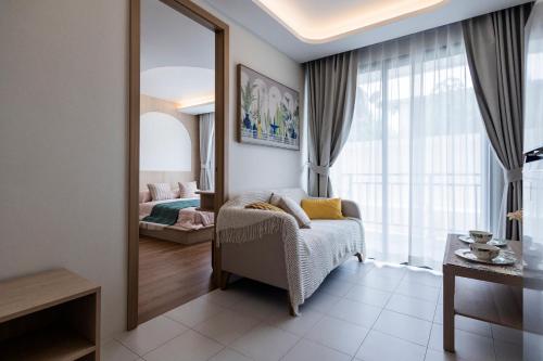 a living room with a chair and a mirror at FantaSea condo Kamala 204 in Kamala Beach