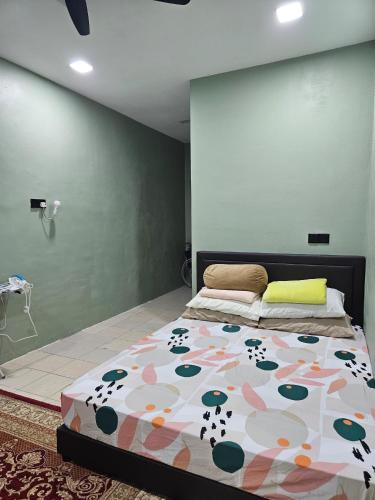 a bedroom with a bed with a floral bedspread at Macchiato Homestay in Klang
