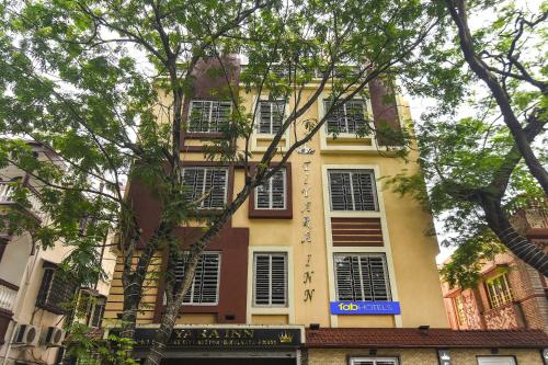 a tall yellow building with windows on a street at FabHotel Prime Tiyara Inn in Kolkata