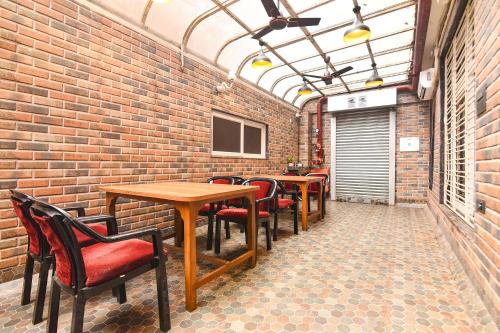 a room with tables and chairs and a brick wall at FabHotel Prime Tiyara Inn in Kolkata