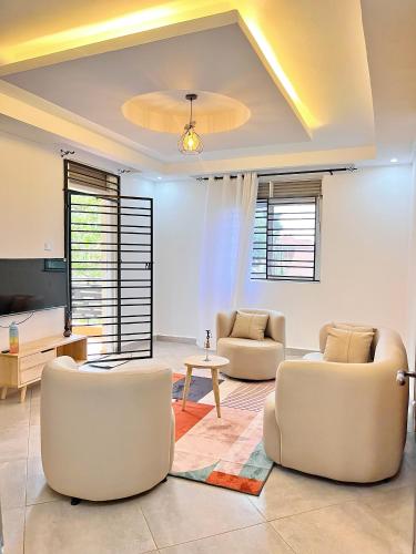 a living room with two chairs and a table at Apartment unit-Luxury in Kampala
