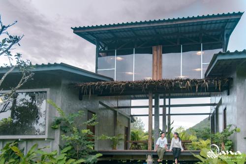 two people sitting on the porch of a house at Nana Villa in Ko Yao Noi