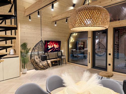 a living room with a tv and a table and chairs at A-Frame LUX in Pavlodar