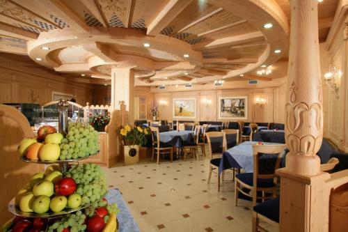 a dining room with tables and chairs and fruit on display at Hotel Garni La Roccia in Andalo