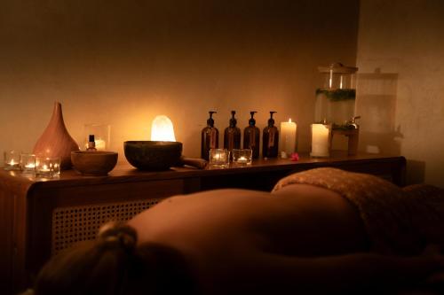 a table with candles and bottles on top of it at Divino Gili Air in Gili Air