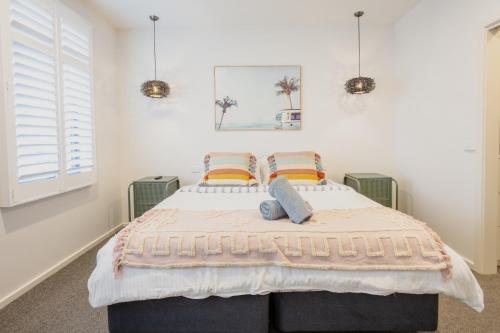 a bedroom with a large bed with two pillows at Bridge Beach House Central Barwon Heads Sleeps 12 Walk everywhere Accessible lower level bedroom and bathroom in Barwon Heads