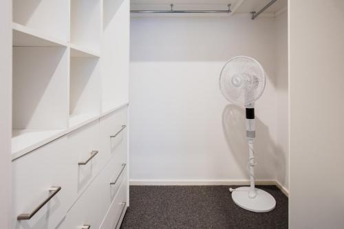 a white closet with a white fan in a room at Bridge Beach House Central Barwon Heads Sleeps 12 Walk everywhere Accessible lower level bedroom and bathroom in Barwon Heads