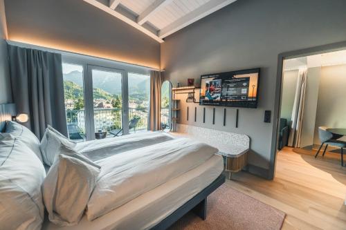 a bedroom with a large bed and a large window at HOP Apartments & Suites in Interlaken
