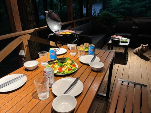 a wooden table with plates of food on a deck at Villa Foresta TERU in Nasu