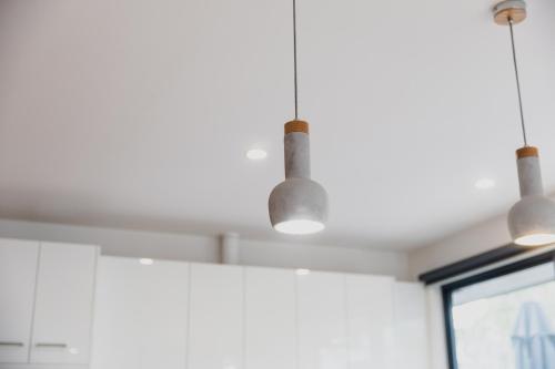 a kitchen with three lights hanging from the ceiling at Bridge Beach House Central Barwon Heads Sleeps 12 Walk everywhere Accessible lower level bedroom and bathroom in Barwon Heads