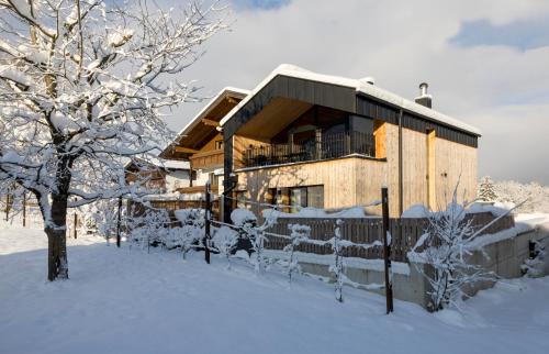 a house covered in snow with a fence at Haus Sonnblick Chalet in Reith im Alpbachtal