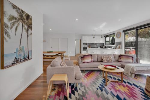 a living room with a couch and a table at Bridge Beach House Central Barwon Heads Sleeps 12 Walk everywhere Accessible lower level bedroom and bathroom in Barwon Heads