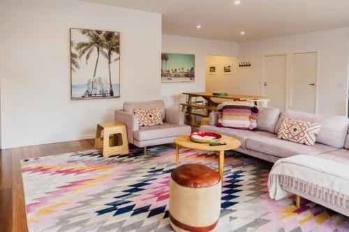 a living room with a couch and a table at Bridge Beach House Central Barwon Heads Sleeps 12 Walk everywhere Accessible lower level bedroom and bathroom in Barwon Heads