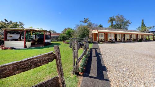 a building with a fence in front of it at Alstonville Settlers Motel in Alstonville