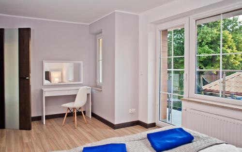 1 dormitorio con cama, escritorio y ventana en Haller House Apartamenty en Władysławowo