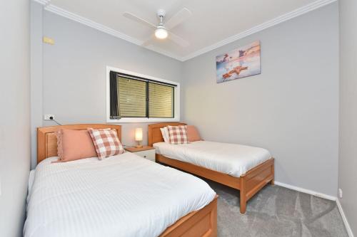 a small bedroom with two beds and a window at Oasis at Salamander Bay in Salamander Bay