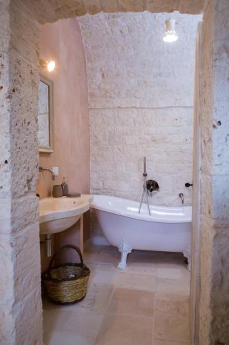 a bathroom with a white tub and a sink at Le Dieci Porte in Alberobello