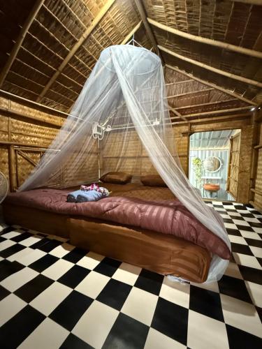 Bett in einem Zimmer mit Moskitonetz in der Unterkunft Be Faanny House in Ko Lanta