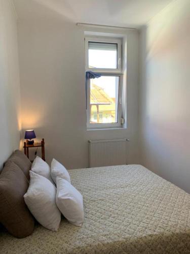 a bedroom with a bed with pillows and a window at Kempelen kúria in Esztergom