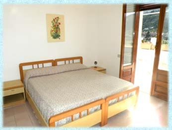 a bedroom with a bed and a sliding glass door at Baia Unci in Canneto