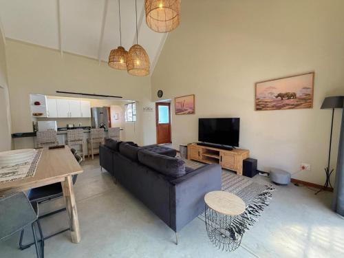 a living room with a couch and a table at Plumtree House in Hoedspruit