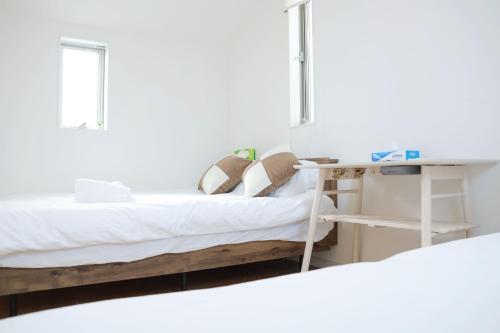 a bedroom with two beds and a desk at SunRise STAY Haruna in Tokyo