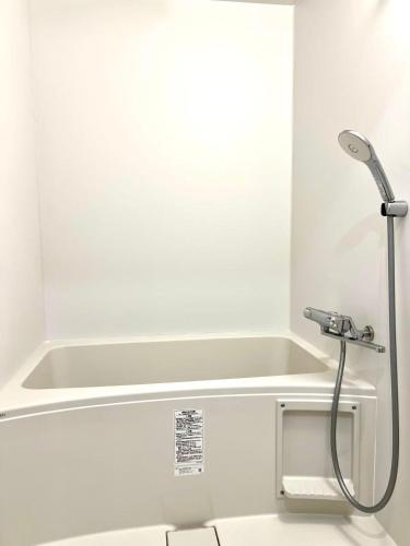 a shower in a bathroom with a white tub at hotel gala city only 5 mins to Kokusai Street 24 square meters room in Naha