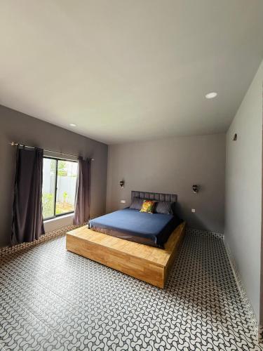 a bedroom with a bed with blue sheets and a window at Angkor Piseth Homestay in Siem Reap