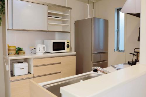 a kitchen with a sink and a microwave at SunRise STAY Haruna in Tokyo