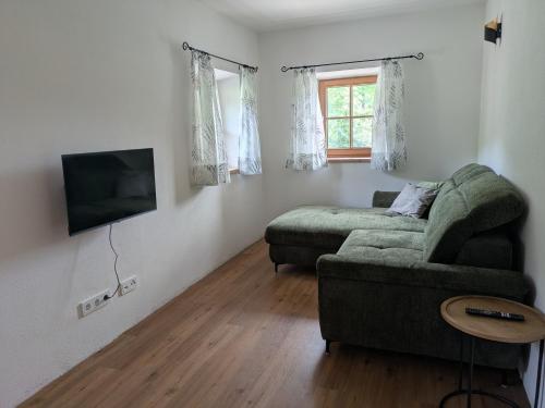 a living room with a couch and a flat screen tv at Bachbauer am Attersee in Weyregg