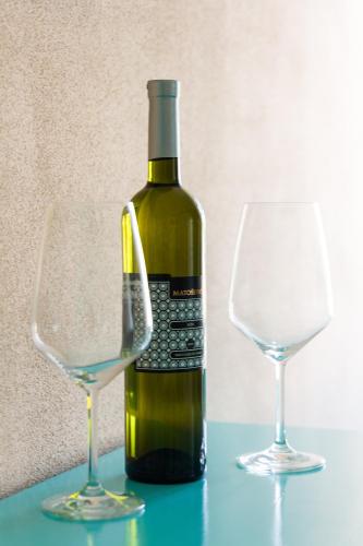 a bottle of wine next to two glasses on a table at Heritage Hotel Chersin in Fažana