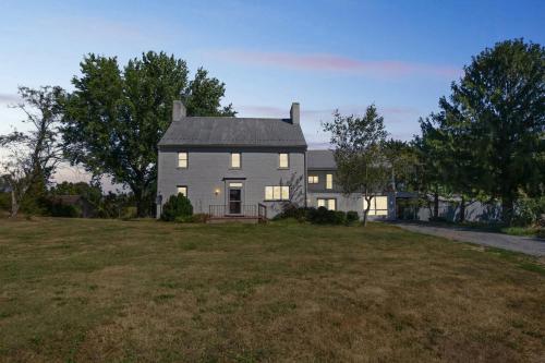 ein weißes Haus mit grauem Dach auf einem Feld in der Unterkunft Peaceful Retreat with Scenic Surroundings home in Inwood