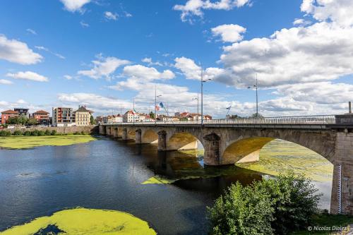 a bridge with a train on it over a river at Le Sunshine, 5 chambres, wifi et parking inclus in Le Coteau