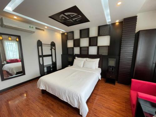 a bedroom with a white bed and a red couch at WILD LOTUS Apartment HA NOI in Hanoi