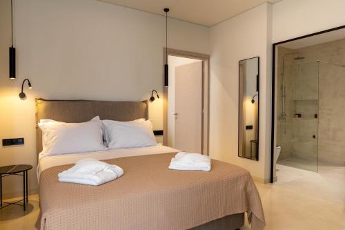 a bedroom with a bed with two towels on it at Alkida Luxury Rooms Tolo in Tolo