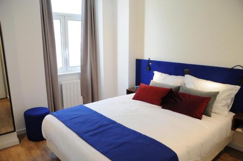 a bedroom with a blue and white bed with red pillows at Lisbonne Appartements in Lisbon