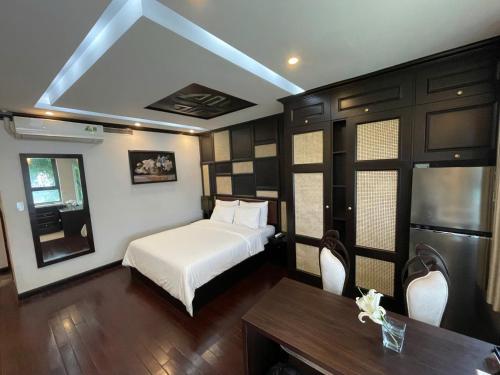 a bedroom with a bed and a table and chairs at WILD LOTUS Apartment HA NOI in Hanoi