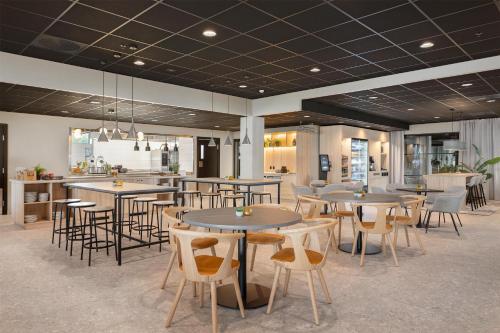 a restaurant with tables and chairs and a bar at Radisson Hotel Haugesund in Haugesund