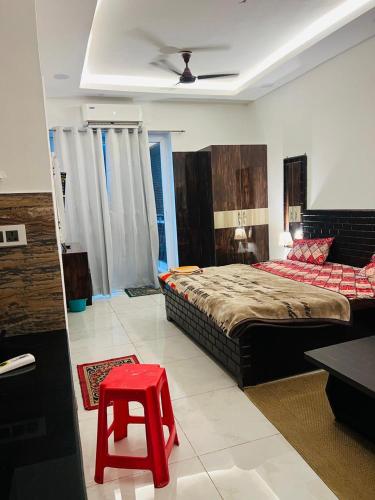 a bedroom with a bed and a red stool at Classic studio in Noida