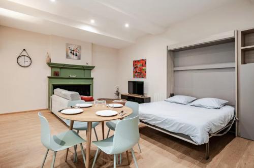 a bedroom with a bed and a table and chairs at Maison des Moines Terrasse & Confort in Valence