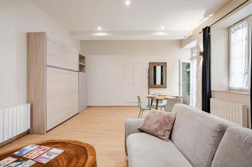 a living room with a couch and a table at Maison des Moines Terrasse & Confort in Valence