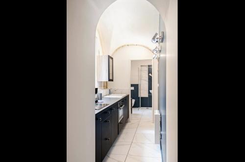 a kitchen with a large archway over a sink at Maison des Moines Terrasse & Confort in Valence