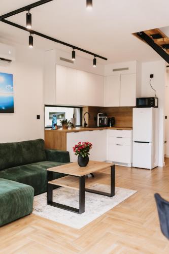a living room with a green couch and a coffee table at Treehouses in Skorochów