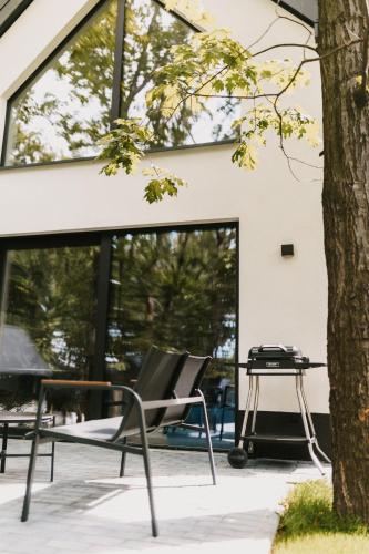 a pair of chairs and a grill in front of a building at Treehouses in Skorochów