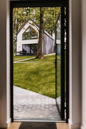 an open door to a yard with a house at Treehouses in Skorochów